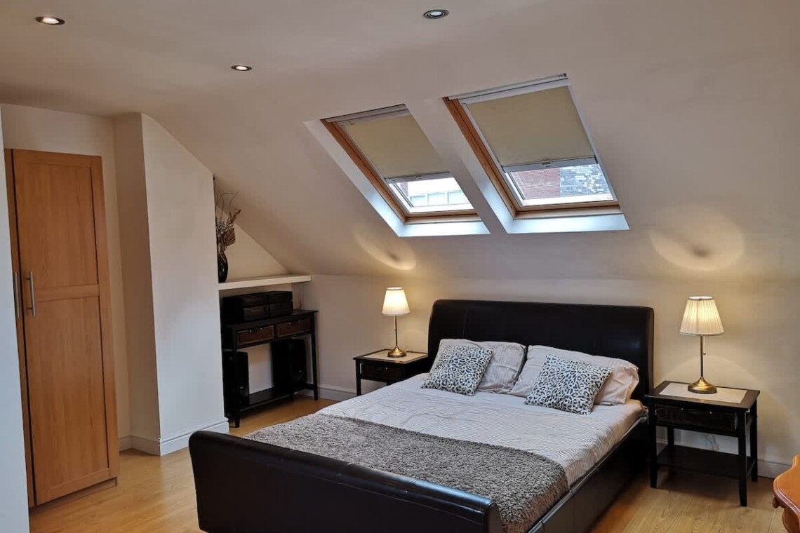 A large, private retreat with a king-size bed, ensuite bathroom, desk, and mini fridge—ideal for longer stays or added privacy.